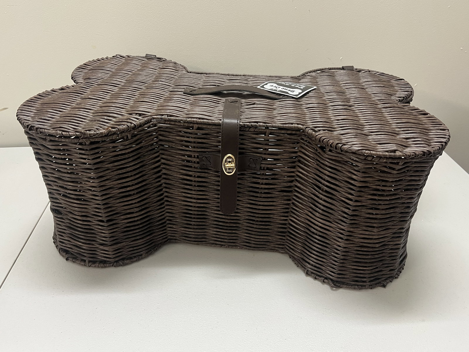 Bone Shaped Dog Toy Basket: Faux rattan. Dimensions: L 24" x W 15" Condition: New Low Estimate: 10.00 High Estimate: 10000.00