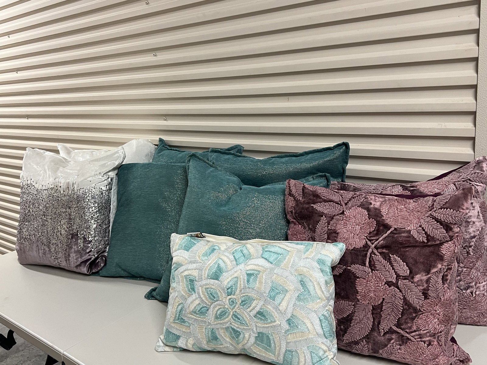 (9) Decorative Throw Pillows: Beaded, embroidered, teal with silver threads and more. All down filled. Dimensions: Largest: 20" Condition: Lightly used. Low Estimate: 10.00 High Estimate: 10000.00