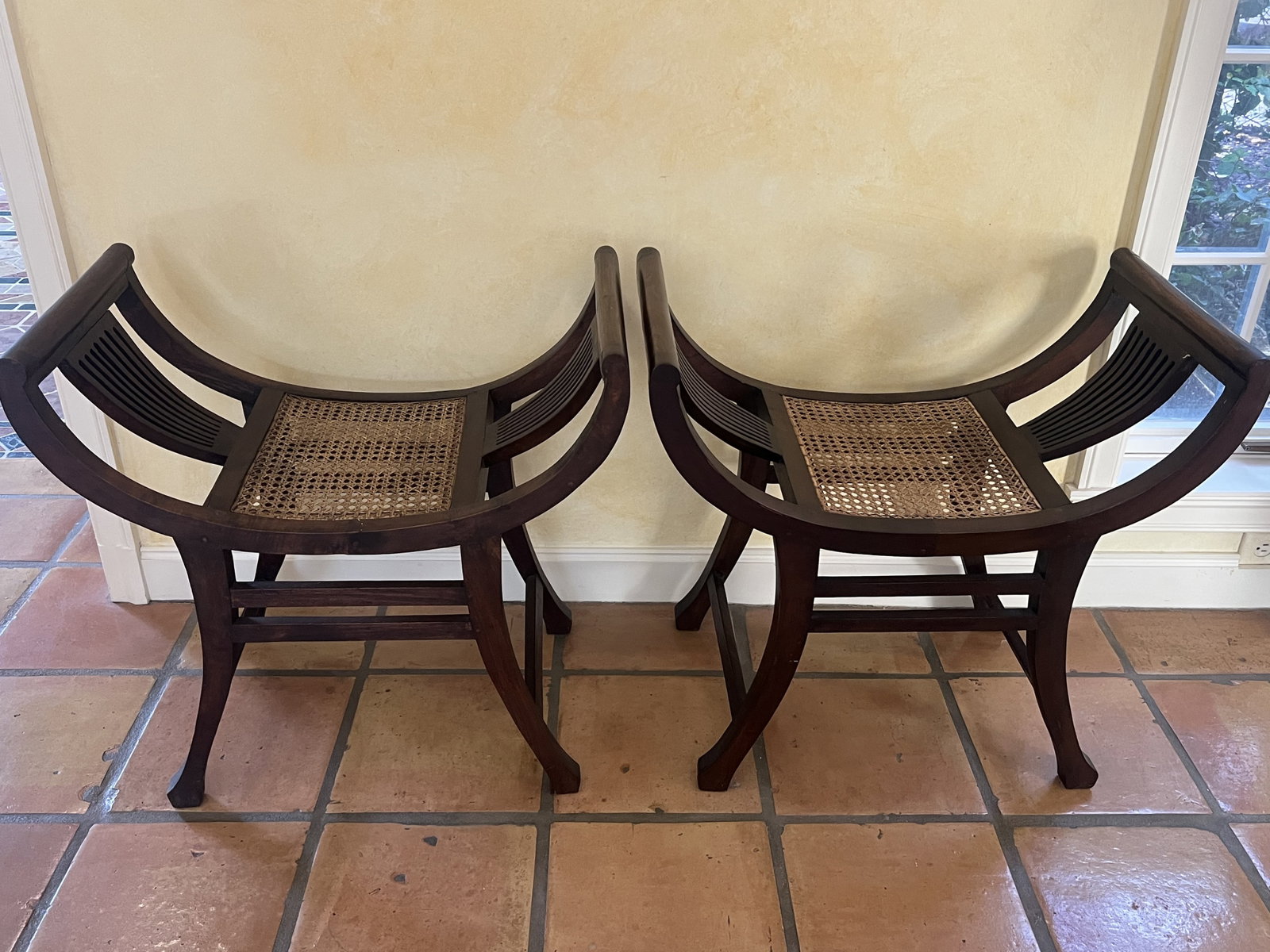 Pair of Indonesian Wood and Cane Stools: Pair of wood and cane stools in classic Indonesian design. Accompanied by down upholstered cushions. Dimensions: L 27.5" x W 16" x H 26.5" x Seat Height: 17.5" Condition: Presenting well, sturdy, no