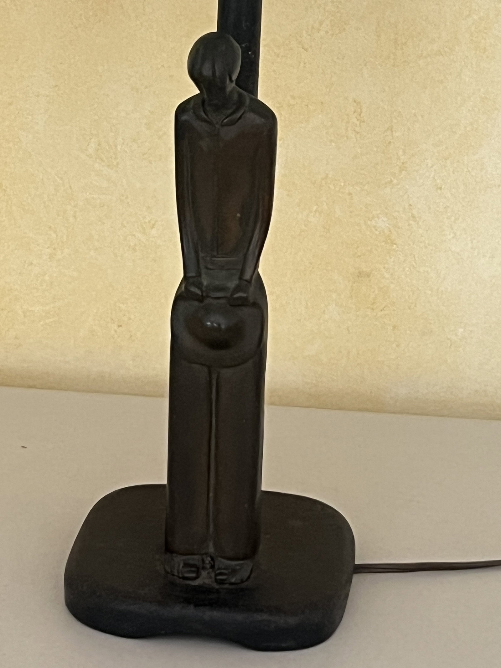 Bronze Figure Lamp: A bronze figure mounted on iron base. Depicting a somber or tired man holding his hat. No signatures or marks, Dimensions: H 12" (to top of figure) x H 26" (overall) Low Estimate: 10.00 High