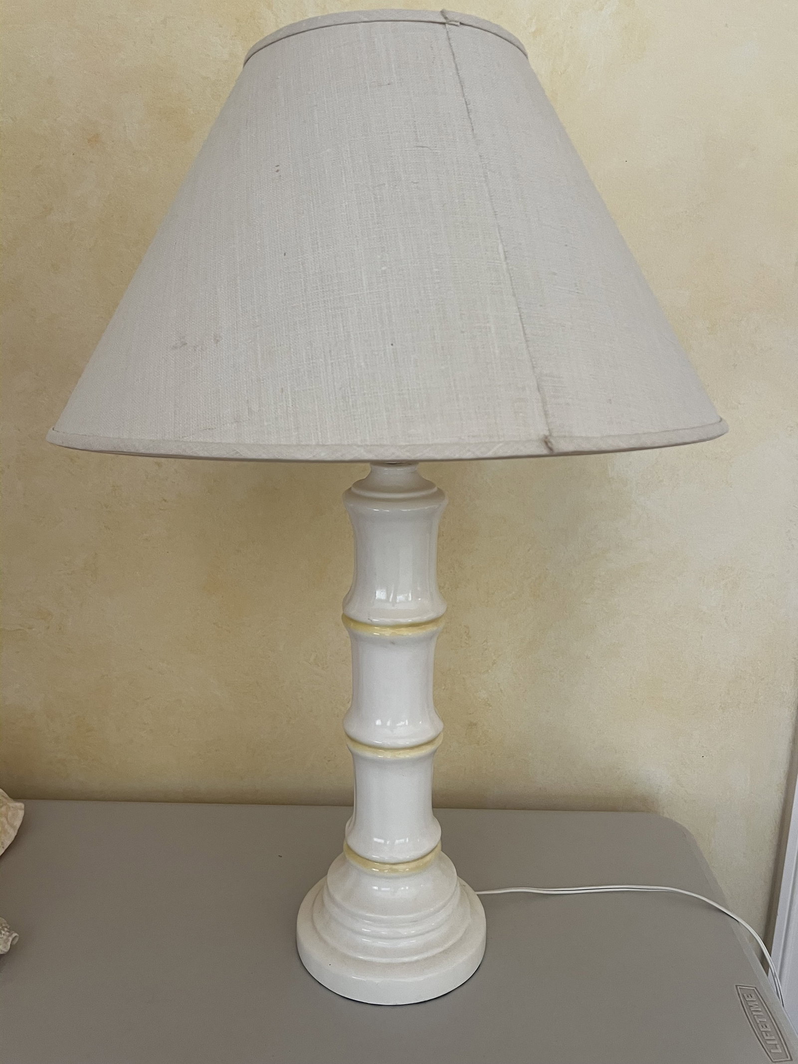 White and Yellow Bamboo Table Lamp: A vintage ceramic table lamp, a bamboo column. Dimensions: H 28" x Dia: 7" Condition: Minor chip where cord enters. Low Estimate: 10.00 High Estimate: 10000.00
