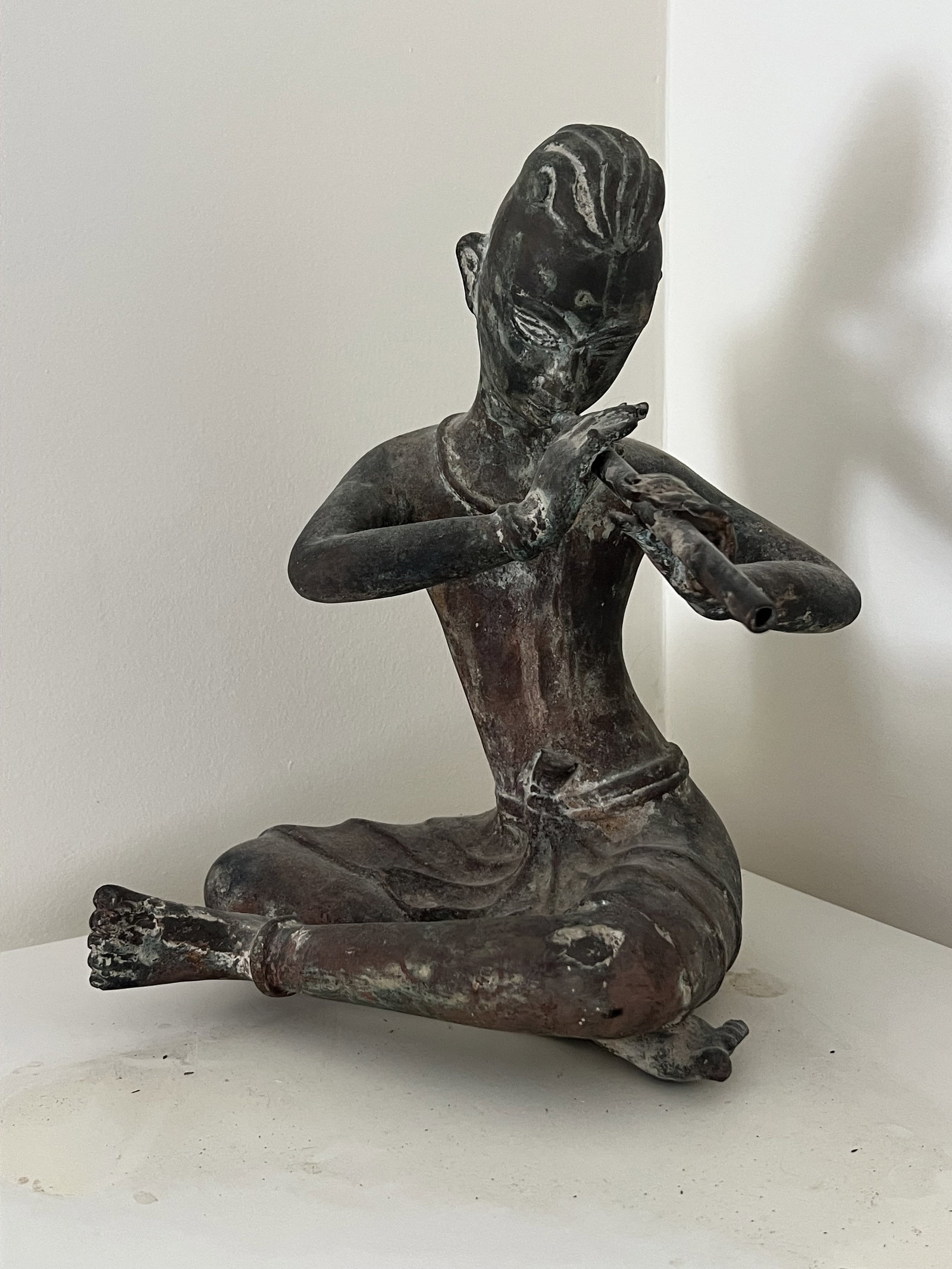 Antique Thai Bronze Flute Player: Snake boy playing a flute. Thai, old auction sticker on bottom. Dimensions: H 13" x W 9" x D 9" Condition: Nice patina. Low Estimate: 10.00 High Estimate: 10000.00
