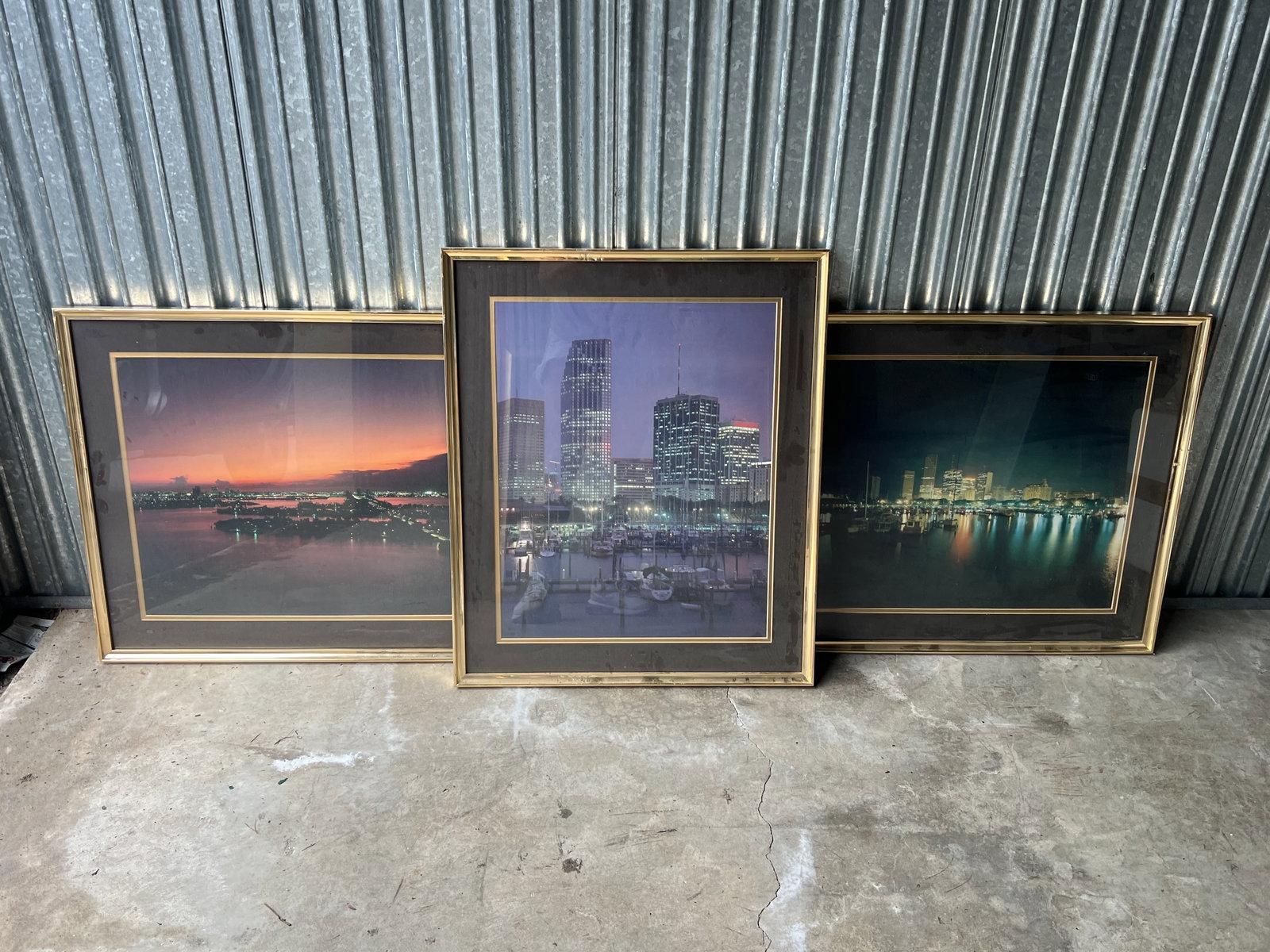 (3) Miami Skyline Photograph Prints: Cityscapes in retro brass/gold frames. Dimensions: H 25" x W 21" Condition; Minor marks to frames Low Estimate: 10.00 High Estimate: 10000.00