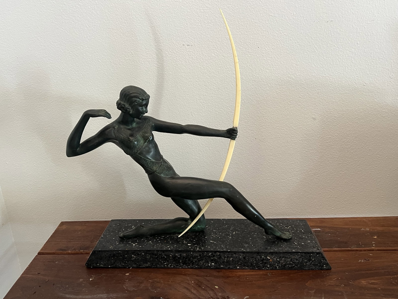 Art Deco Greek Bronze The Archer Sculpture: Diana the huntress, Art Deco bronze on terrazzo base with composite bow. Unsigned with great patina. Dimensions: H 20" (overall including bow) x W 19.5" x D 5" Condition: Bow with some loss at