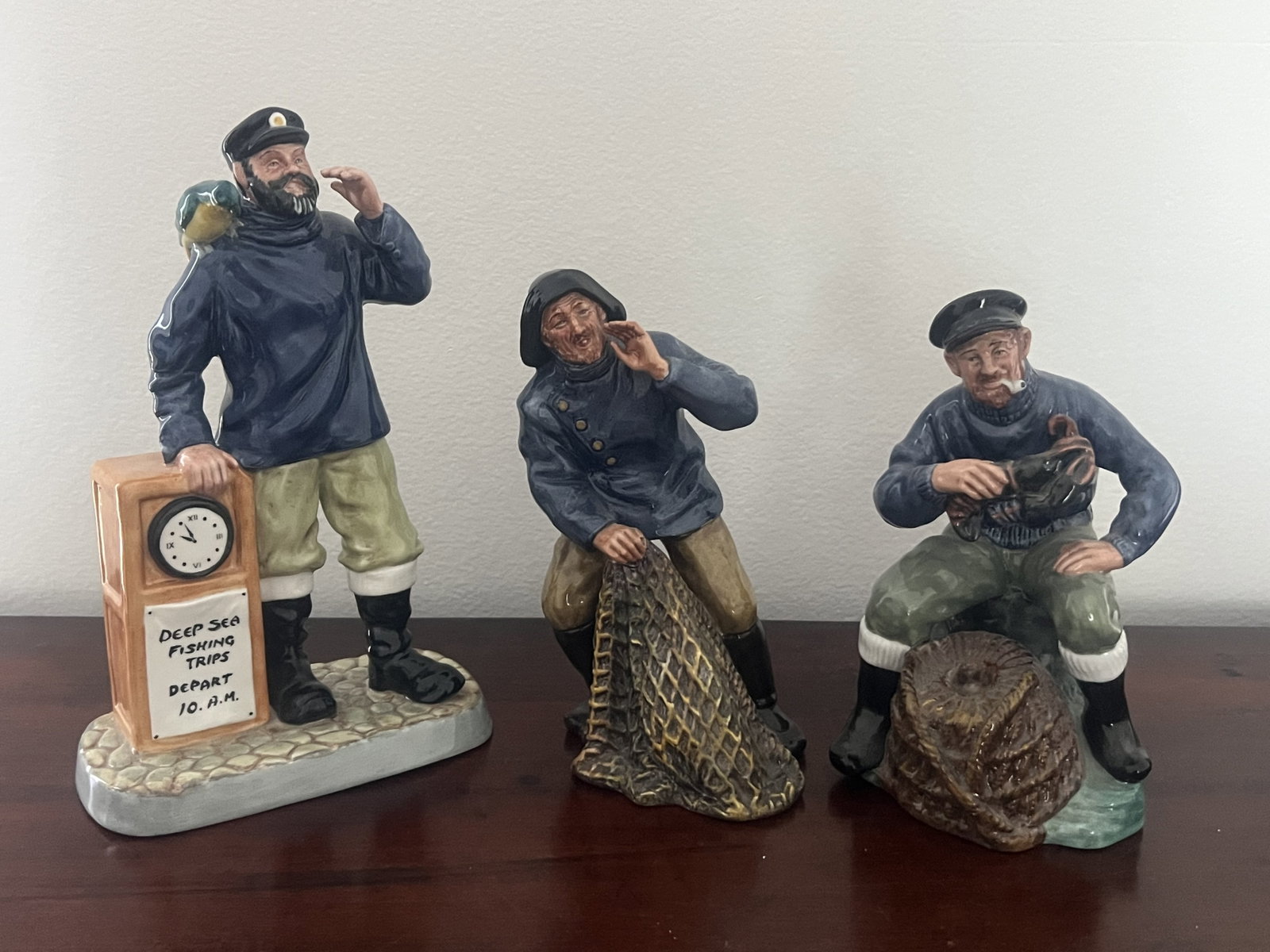 (3) Royal Doulton Fisherman Blue and White Figurines: The Lobster Man HN 2317, Sea Harvest HN 2257, All Aboard HN 2940. Dimensions: Largest: H 9.5" x W 6" Condition: No issues to note. Low Estimate: 10.00 High Estimate: 10000.00
