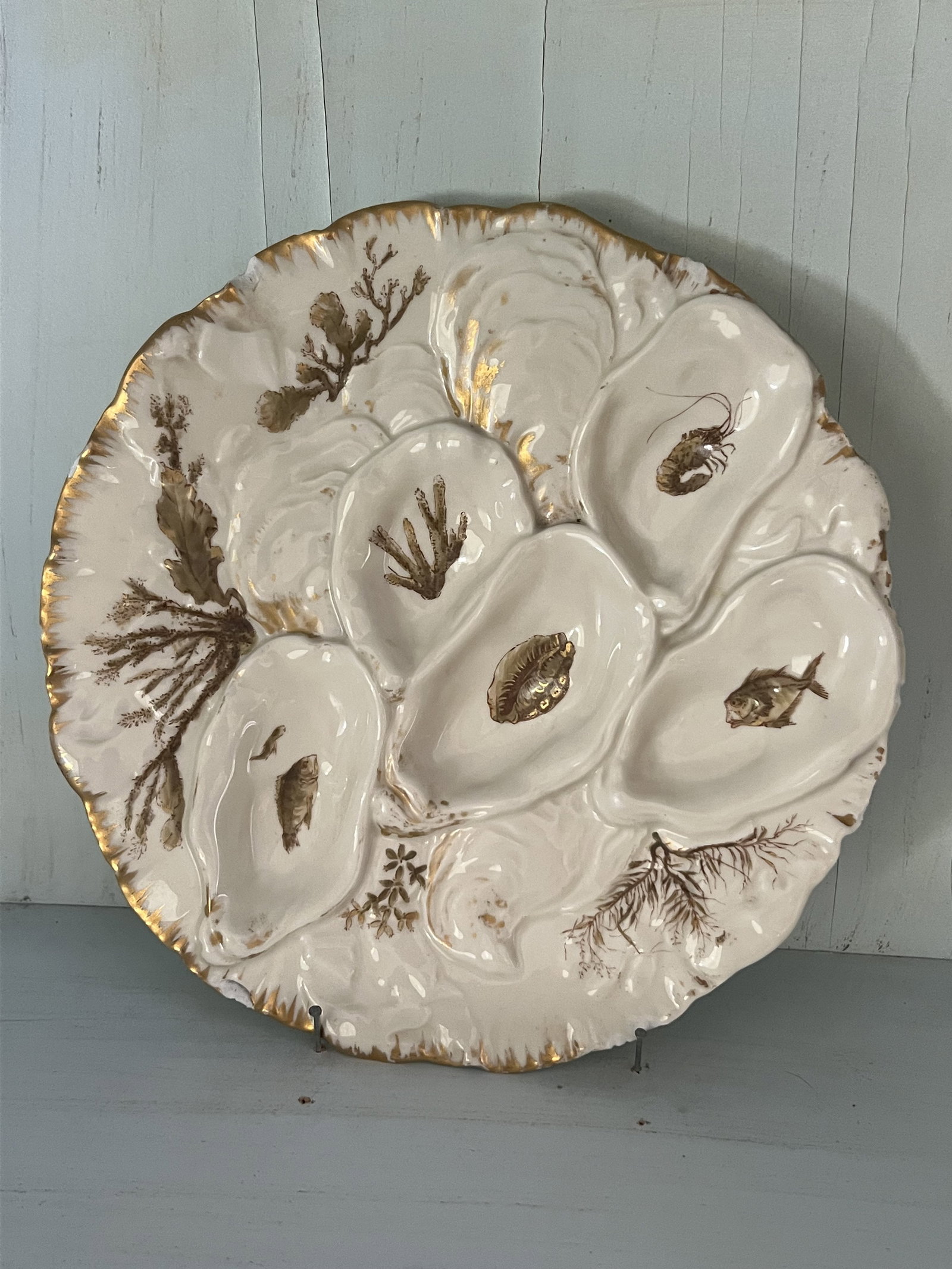 Haviland Limoges Oyster Plate: Antique oyster plate in cream color with gold accents. Dimensions: almost 9" Condition: Some edge chips as pictured. Low Estimate: 10 High Estimate: 10000