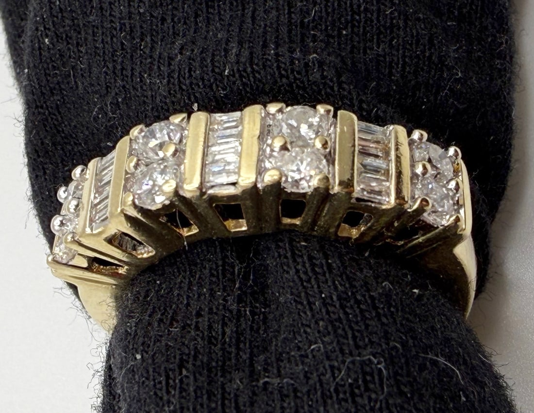 14K ROUND AND BAGUETTE DIAMOND BAND WITH RECENT APPRAISAL: One 14K yellow gold round and baguette diamond band. Mounted in this band in seven vertical rows are a total of eight round brilliant cut diamonds and twelve straight cut baguette diamonds. The round