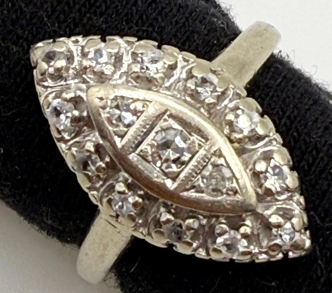 14K WHITE GOLD ANTIQUE DIAMOND DESIGN RING: One 14k white gold diamond antique design ring. Mounted in the center of this ring are three melee single cut diamonds. Mounted around the outside of this marquise shaped ring are twelve cubic zirconi