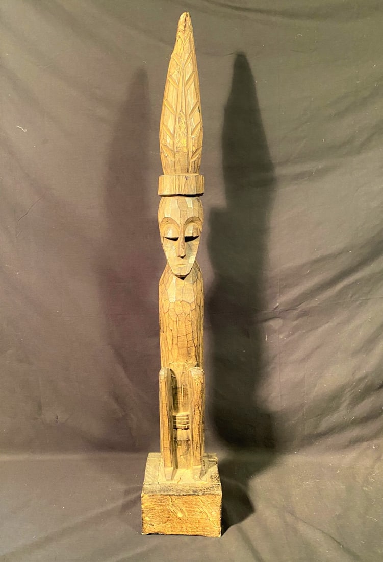 BALINESE STATUE MADE OF ALBACIA WOOD – 39 IN TALL: Original Balinese carved statue made from Albacia wood. These types of statues were used as a type of tombstone thousands of years ago. More recently, they are used in funeral proceedings. They are be