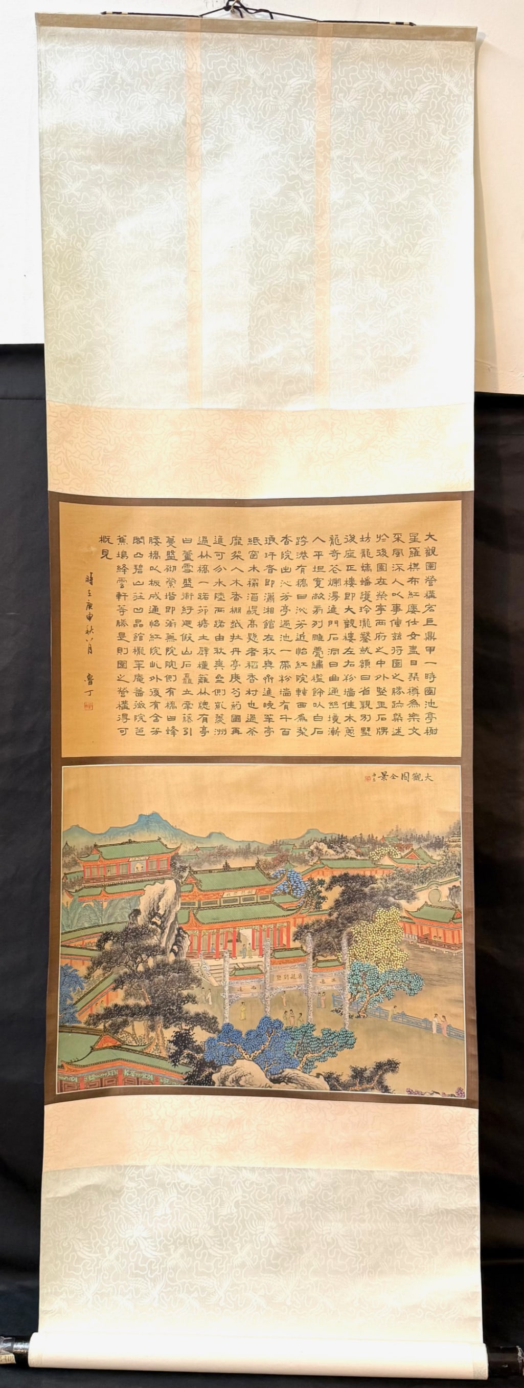 CHINESE SILK HANGING SCROLL TITLED GRAND VEIW GARDEN PANORAMA, 20 th CENTURY WITH BOX, 22IN x 70IN: A finely detailed Chinese architectural landscape painting depicting “Grand View Garden” in panoramic view. The composition presents an expansive palace and garden complex rendered in meticulo