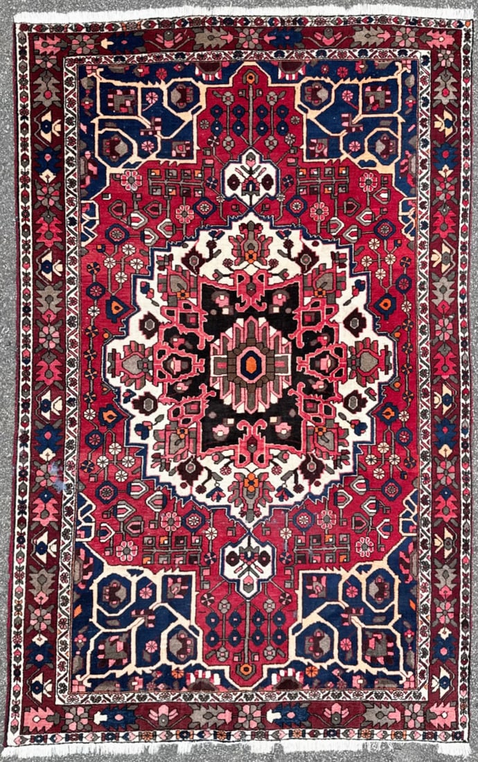 PERSIAN BAKHTIARI HAND KNOTTED RUG, 6.7 x 10.4 (201cm x 315cm): This hand-knotted Persian Bakhtiari rug carries the kind of visual weight and cultural depth that defines a truly finished interior. The composition is anchored by a striking ivory-ground central meda