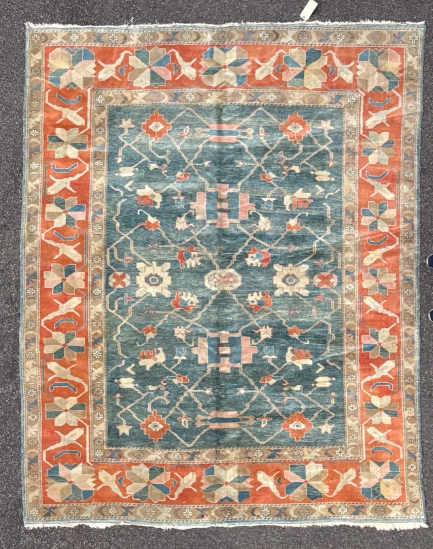 CAUCASIAN KAZAK HAND KNOTTED RUG, 9.0 x 11.2 (274cm x 340cm): An exceptional hand-knotted wool rug woven in the highly sought-after Caucasian Kazak revival tradition, featuring a striking oxidized teal field framed by a richly saturated coral border with bold ge