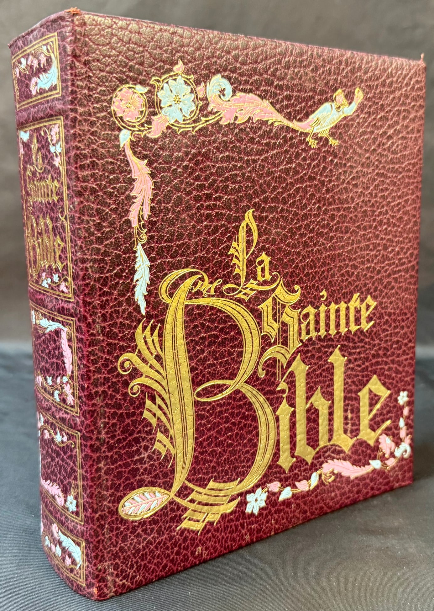 FRENCH ILLUMINATED-STYLE LEATHER BIBLE, GILT AND POLYCHROME BINDING, LUXURY EUROPEAN LIBRARY: A striking French luxury edition of La Sainte Bible, produced in Paris in 1979 and bound in a richly textured burgundy leather with elaborate gilt and polychrome tooling, executed in the grand traditi