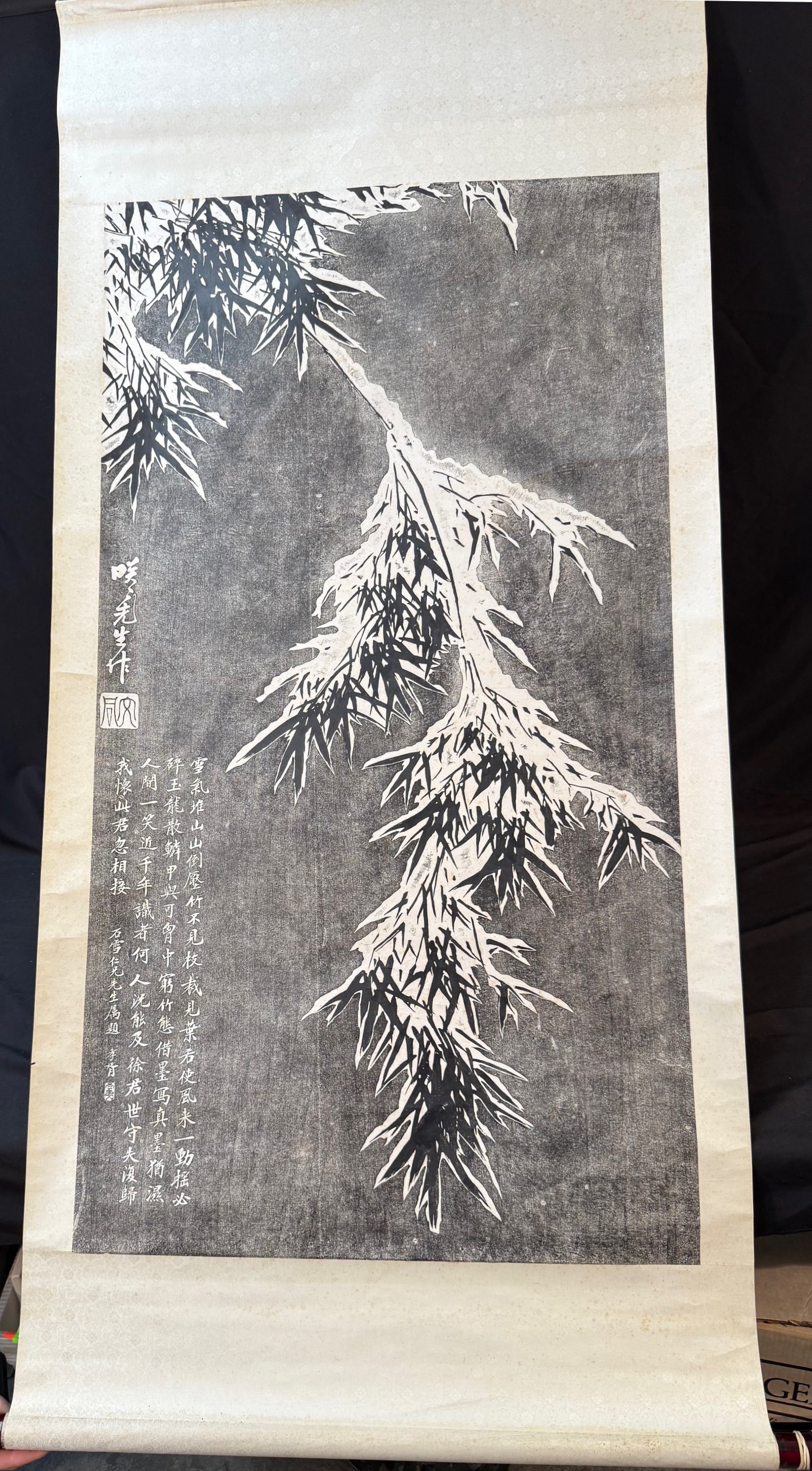 CHINESE SCROLL OF BAMBOO MADE BY PHOTO INK, 31IN x 68IN (79cm x 173cm): A Chinese scroll of a snow-covered bamboo branch in black and white. It is believed to be an ink print. It is adhered to a silk backing. It is signed in the Mid left. The entire scroll measures 31 inc