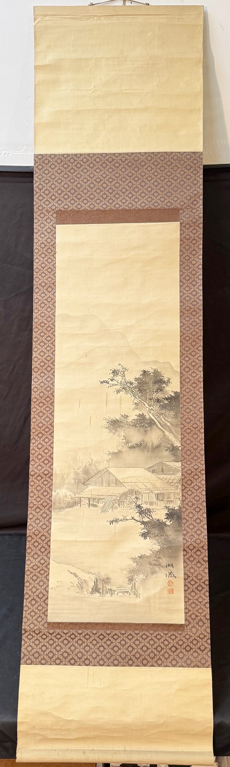 ORIGINAL KOJO (EARLY 20th CENTURY) JAPANESE NIHONGA LANDSCAPE SCROLL PAINTING, 17.5IN x 73.5IN (44cm: An original Kojo (20th Century) Japanese hanging scroll painted in ink on silk and mounted in a traditional three-section silk brocade format. The painting depicts a serene rural scene of a cluster of