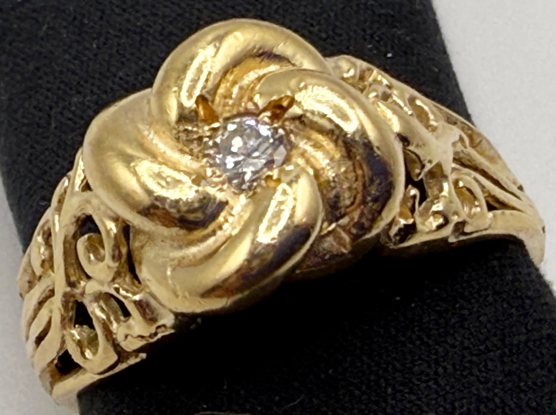 14K YELLOW GOLD AND DIAMOND LOVE KNOT RING: One 14k yellow gold diamond love knot ring. Mounted in the center of the knot is one round brilliant cut diamond. This diamond has an approximate weight of .10cts, color H, and a clarity of SIl. This 