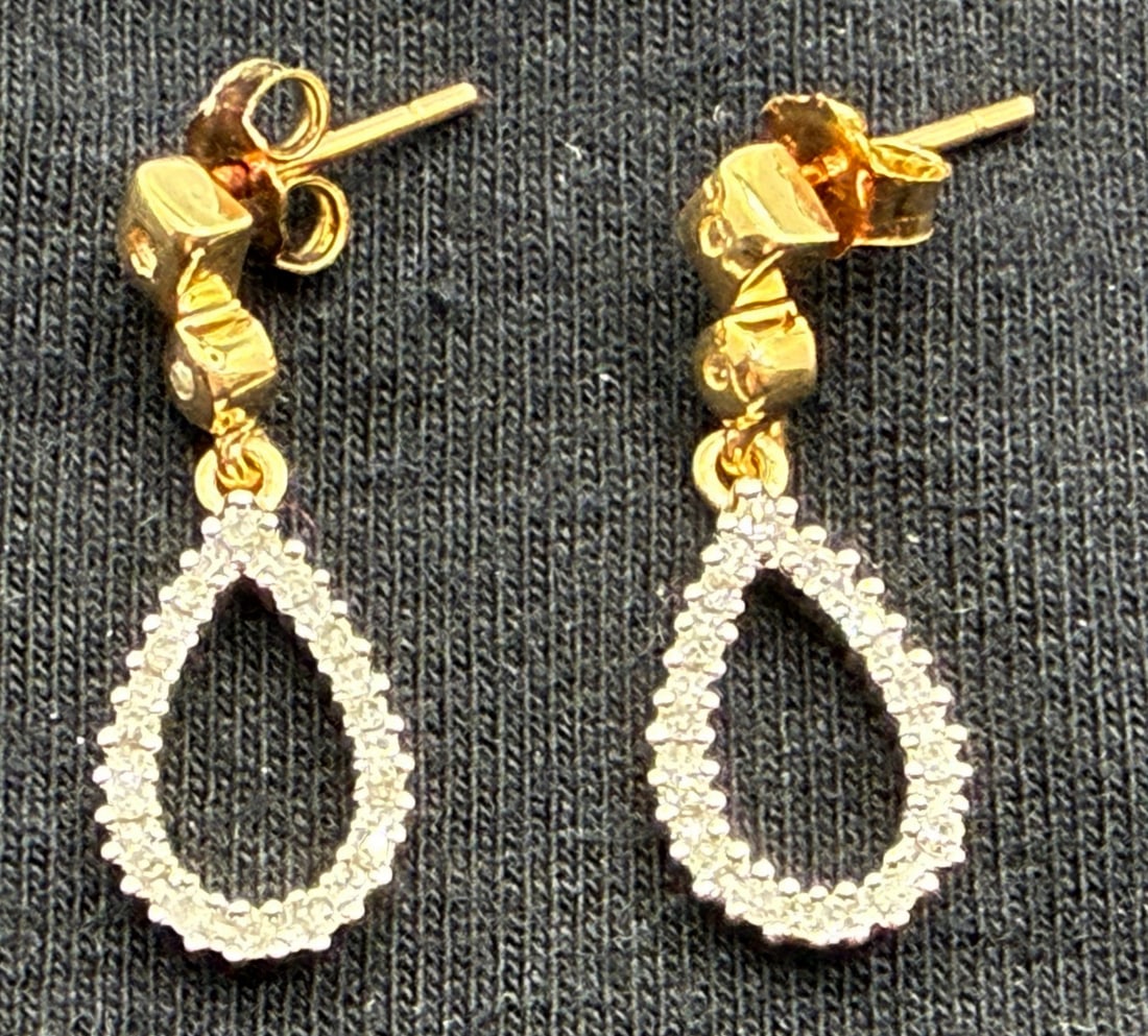 10K DANGLE DIAMOND EARRINGS: One pair of 10k yellow gold dangle diamond earrings. Mounted in these dangle earrings are thirty-two round diamonds, sixteen per earring. These diamonds have an approximate total diamond weight of 10c
