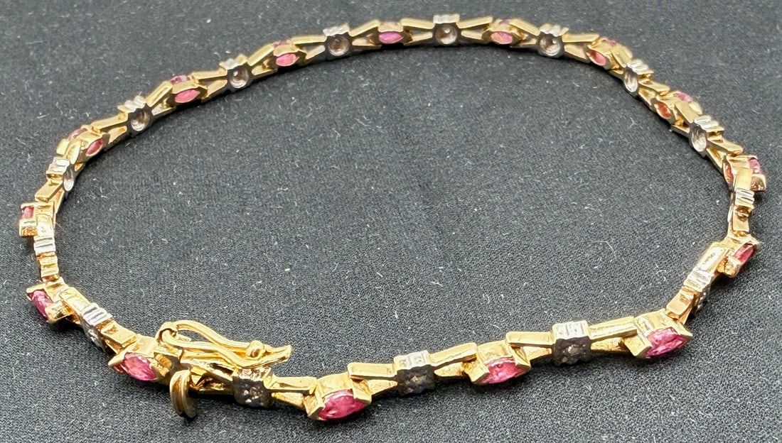 10K YELLOW GOLD, RUBY AND DIAMOND BRACELET: One 10k yellow gold ruby and diamond bracelet. Mounted in this bracelet are fifteen marquise cut rubies that alternate with fifteen single cut melee diamonds. The rubies are B in quality and have a to