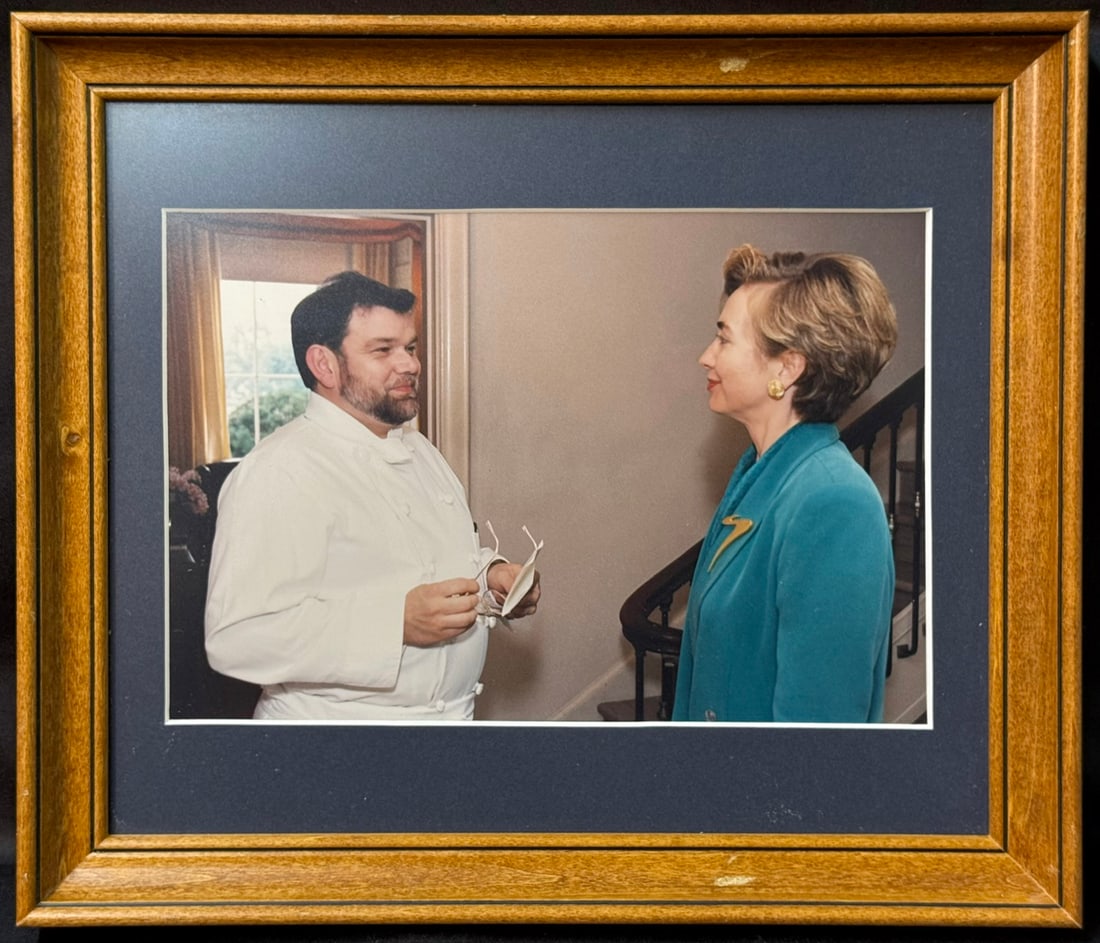 OFFICIAL WHITE HOUSE PHOTOGRAPH OF FIRST LADY HILLARY RODHAM CLINTON WITH EXECUTIVE CHEF PIERRE: An exceptional and historically significant Official White House photograph capturing First Lady Hillary Rodham Clinton in conversation with Executive Chef Pierre Chambrin, offered directly from the p