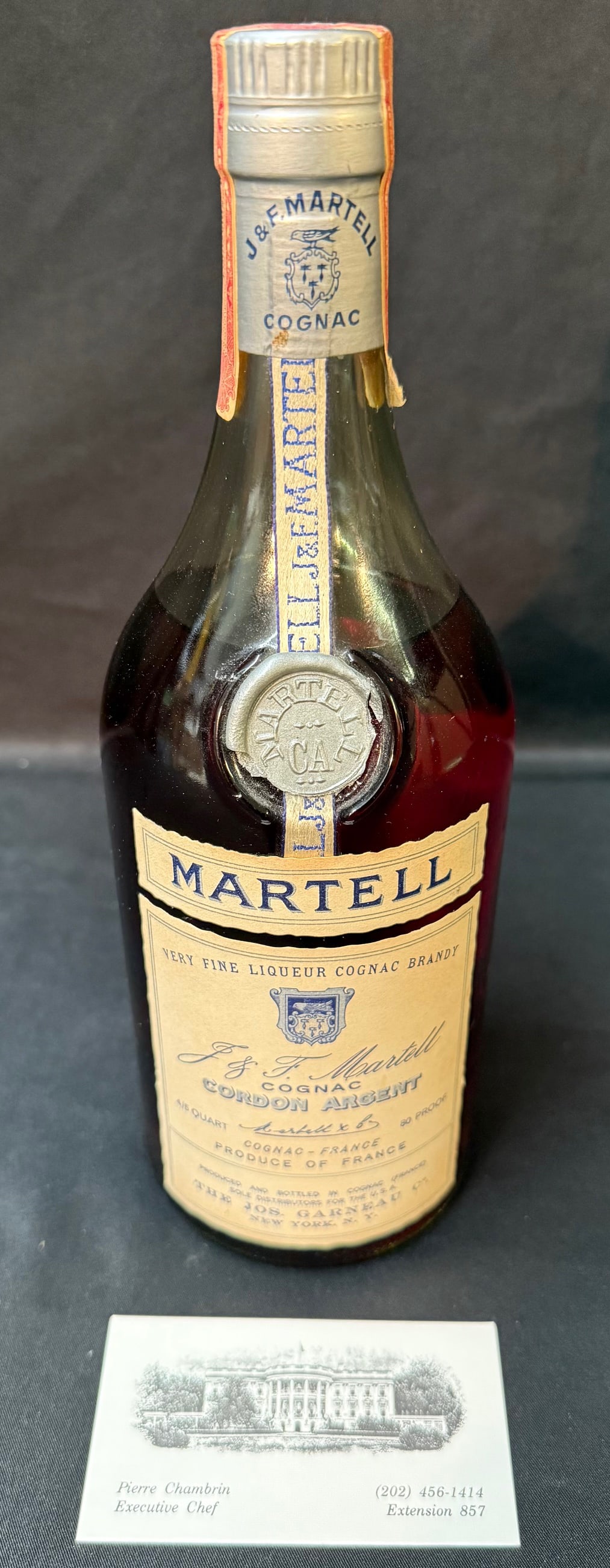 VINTAGE MARTELL COGNAC, MID-20TH CENTURY U.S. EXPORT BOTTLE, PROPERTY FROM THE ESTATE OF PIERRE: Property from the estate of Pierre Chambrin, Executive Chef to two U.S. Presidents (1989–1994), this mid-20th century Martell cognac was retained within his personal cellar and reflects the