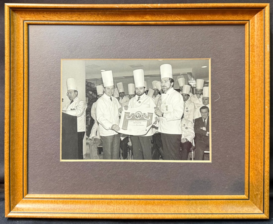 PIERRE CHAMBRIN ACAD?MIE CULINAIRE DE FRANCE DIPLOMA PRESENTATION PHOTOGRAPH, FRAMED PERSONAL ESTATE: An exceptional framed photograph from the personal estate of Pierre Chambrin, former Executive Chef of the White House, capturing Chef Chambrin proudly receiving his Académie Culinaire de France 