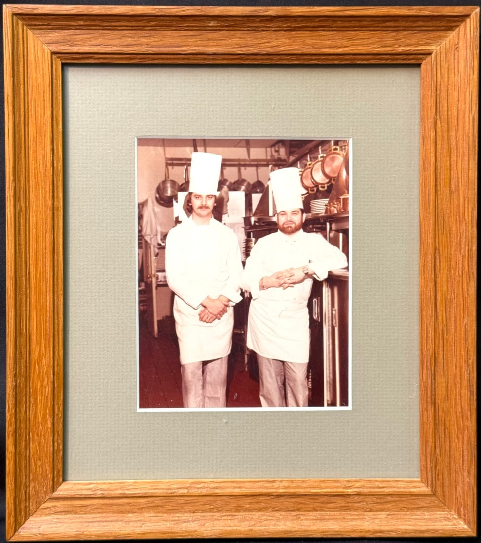 PERSONAL PHOTOGRAPH OF WHITE HOUSE EXECUTIVE CHEF PIERRE CHAMBRIN AND CHEF AUGUSTINO "TINO" BUGGIO,: An exceptionally personal and evocative photograph from the estate of Pierre Chambrin (1939–2018), former Executive Chef of the White House, depicting Chef Chambrin alongside fellow chef and clo