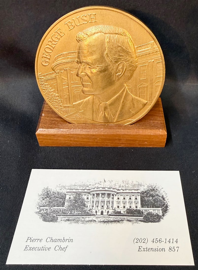GEORGE H.W. BUSH PRESIDENTIAL INAUGURAL MEDALLION ON STAND, WHITE HOUSE EXECUTIVE CHEF PIERRE: A compelling George H.W. Bush presidential inaugural medallion, presented in high-relief bronze tone and mounted on its original wood display base, elevated significantly by direct White House Executi