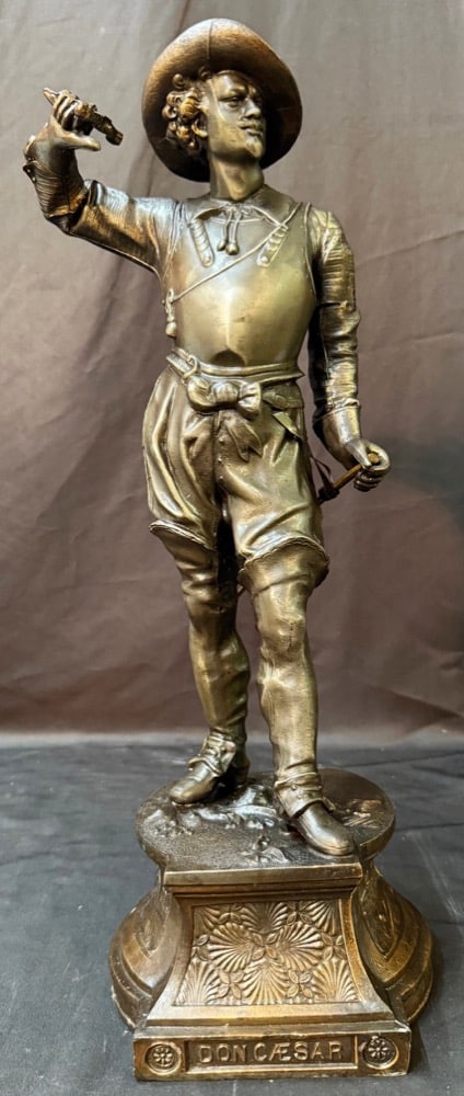 FRENCH SPELTER FIGURE OF DON CAESAR ON DECORATIVE CAST BASE, LATE 19th CENTURY, 21IN x 7IN x 6IN: This striking late, 19th-century French decorative sculpture depicts Don Cæsar de Bazan, the romantic swashbuckling nobleman who became a beloved figure in 19th-century European theater and 
