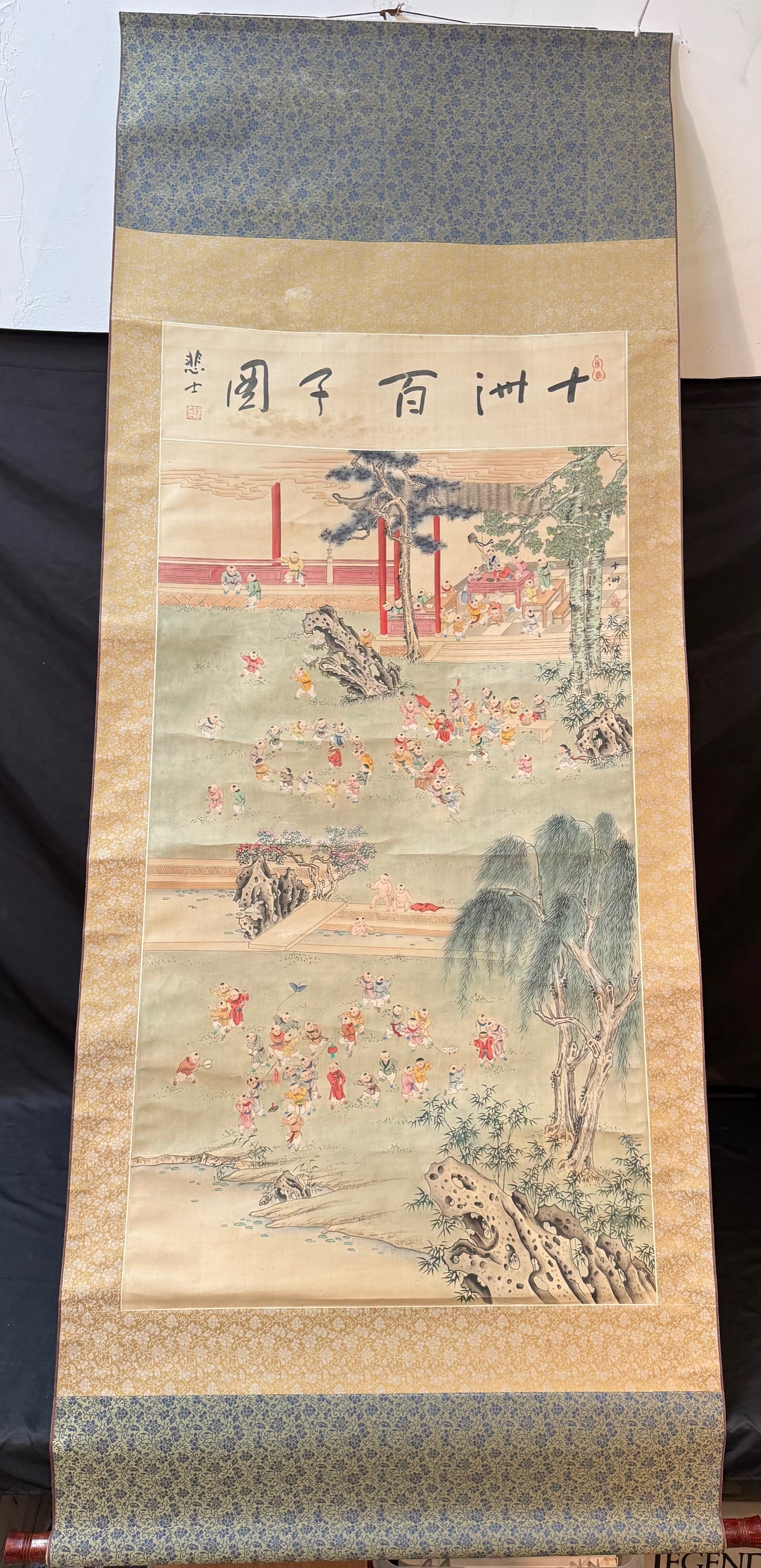 CHINESE ONE HUNDRED BOYS HANGING SCROLL ON SILK, 20TH CENTURY WITH BOX, 30IN x 78IN (76cm x 198cm): A finely executed Chinese figural painting depicting the auspicious theme “One Hundred Boys”, symbolizing fertility, prosperity, and the wish for numerous descendants. The composition