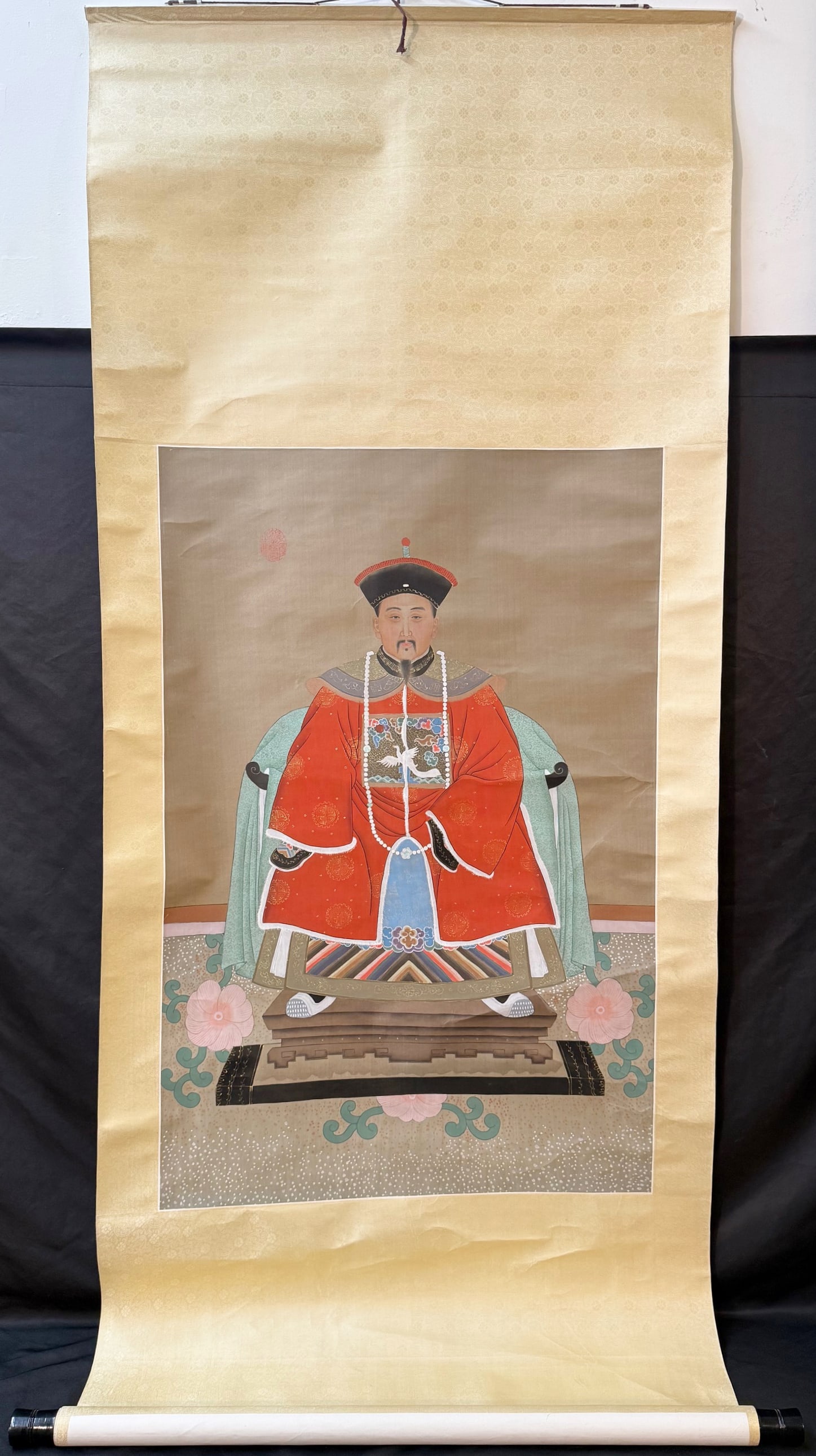 ANTIQUE IMPERIAL ANCESTOR PORTRAIT OF A COURT OFFICIAL OR EMPEROR, 31IN x 74IN (79cm x 188cm): A finely rendered Chinese imperial ancestor portrait, executed in ink and mineral pigments on silk and mounted as a traditional hanging scroll. The composition depicts a dignified male figure sea