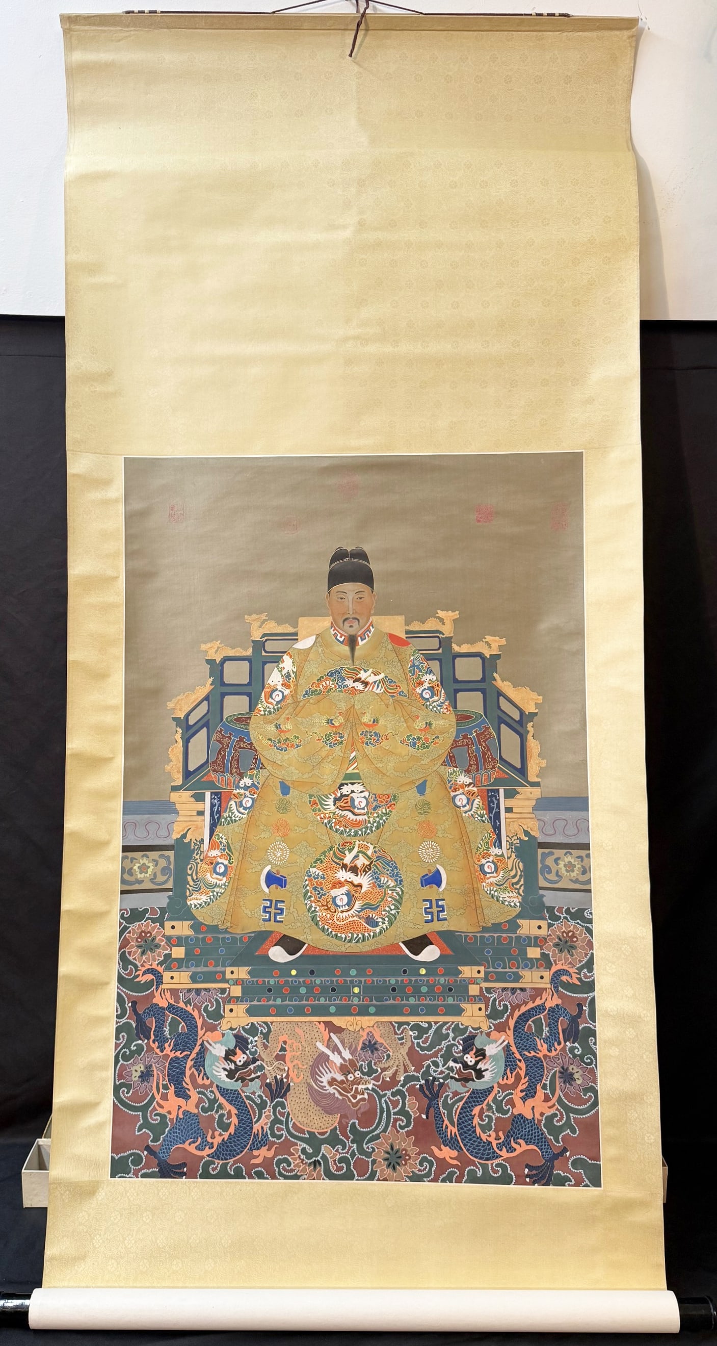 ANTIQUE IMPERIAL ANCESTOR PORTRAIT OF A MING EMPEROR, 31IN x 74IN (79cm x 188cm): A finely executed Chinese imperial ancestor portrait depicting a Ming dynasty emperor, seated frontally in full ceremonial court attire. The composition follows the strict conventions reserved ex