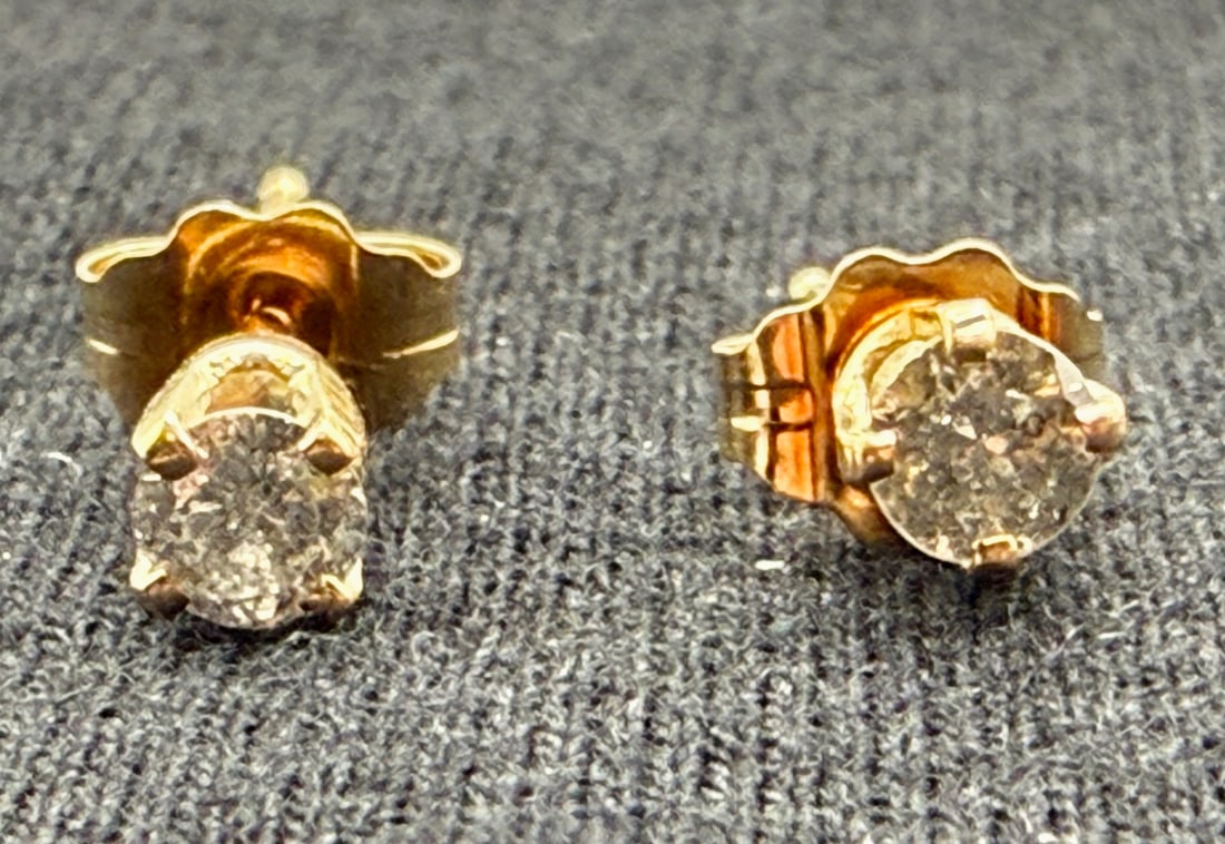 14K DIAMOND STUD EARRINGS: One pair of 14k yellow gold diamond stud earrings. Mounted in each four-prong mounting is one round diamond that has an approximate weight of .10ct, color I and a clarity of 13. These earrings have