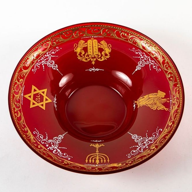 A hand blown bohemian glass vessel in a toffee-red hue, decorated with gold and enamel, Decorated: A hand blown bohemian glass vessel in a toffee-red hue, decorated with gold and enamel, Decorated with Jewish symbols, Height: 6.5 cm, diameter: 24 cm