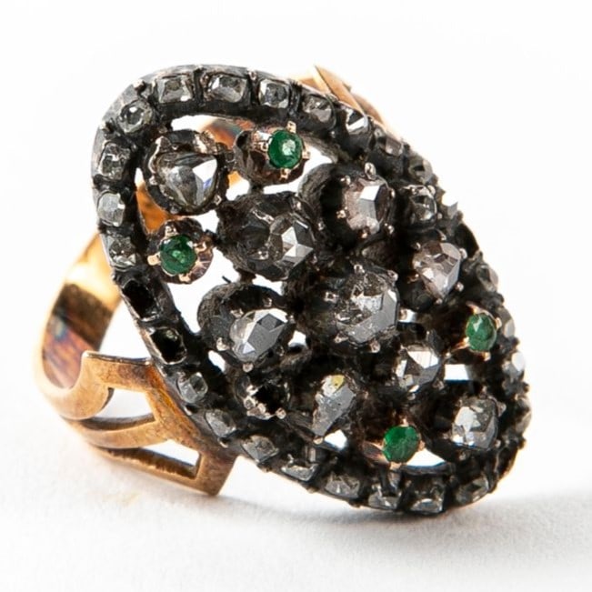 An antique ring from the end of the19th century, made of gold and silver, set with emeralds and: An antique ring from the end of the19th century, made of gold and silver, set with emeralds and diamonds in antique polishing (rose cut), five diamonds are missing, Gross weight: 8g, diameter: 16mm