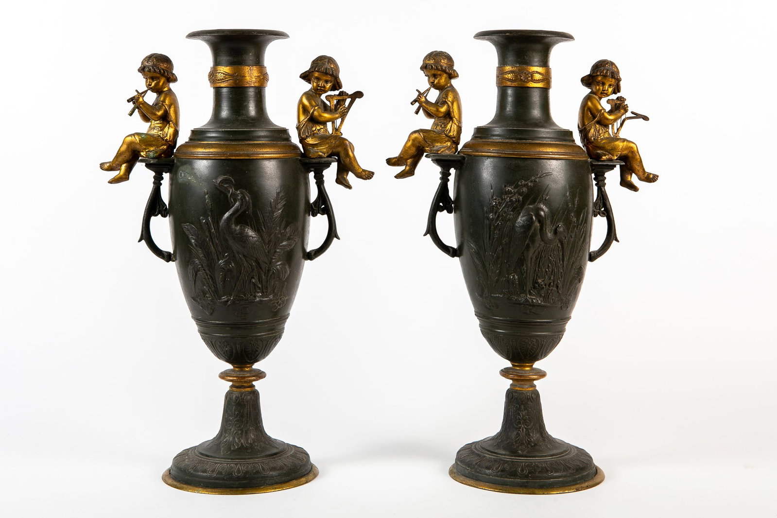 A pair of antique French spelter svases from the second half of the 19th century, decorated with: A pair of antique French spelter svases from the second half of the 19th century, decorated with relief decorations, partially gilded, flaw to one harp, Height: 40.5 cm, total width: 25 cm,