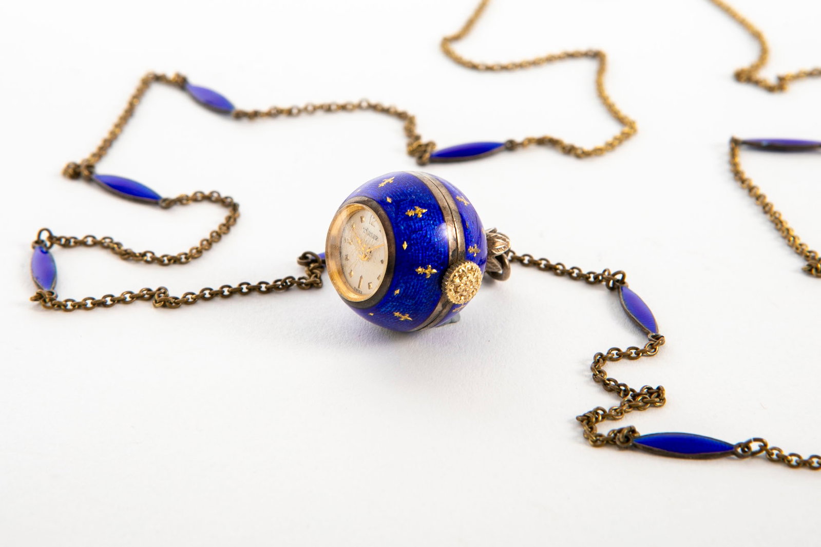 Chain and pendant (watch), made of metal decorated with blue enamel, the watch is signed 'Turler',: Chain and pendant (watch), made of metal decorated with blue enamel, the watch is signed 'Turler', the chain is decorated with enamel, working condition not tested, The diameter of the pendant: 1.8 cm