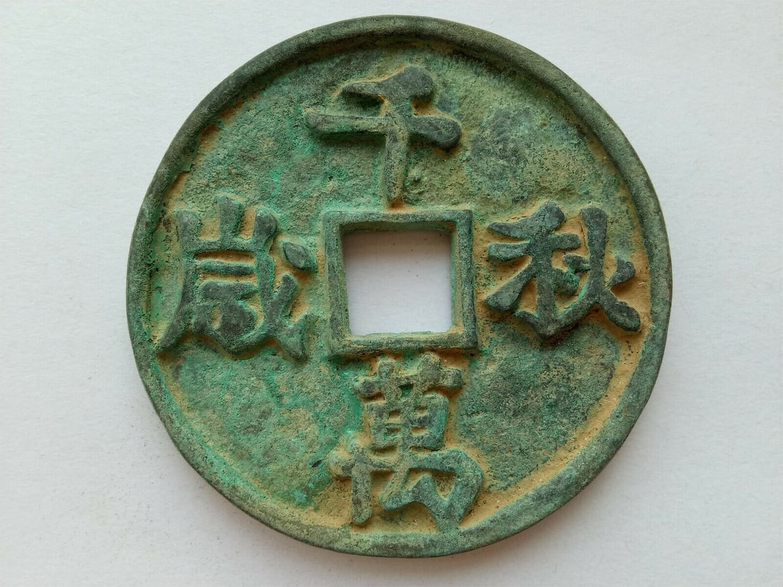 Vintage-Style Bronze Coin Replica Qian Qiu Wan Sui: Size: Diameter 56 mm. Materials: Bronze. Condition: Excellent. This vintage-inspired bronze coin is a replica with the inscription "QIAN QIU WAN SUI" on the obverse. Crafted from bronze, it features a