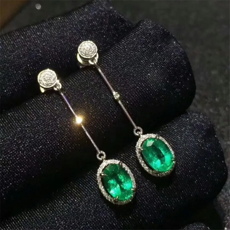 Green Emerald Drop Earrings Silver 925 Oval Cut: Size: Stone size 6 x 4 mm. Weight 2 g. Materials: 925 sterling silver, emerald, zircon. Condition: New. This pair of drop earrings is crafted from 925 sterling silver and highlights oval-cut green