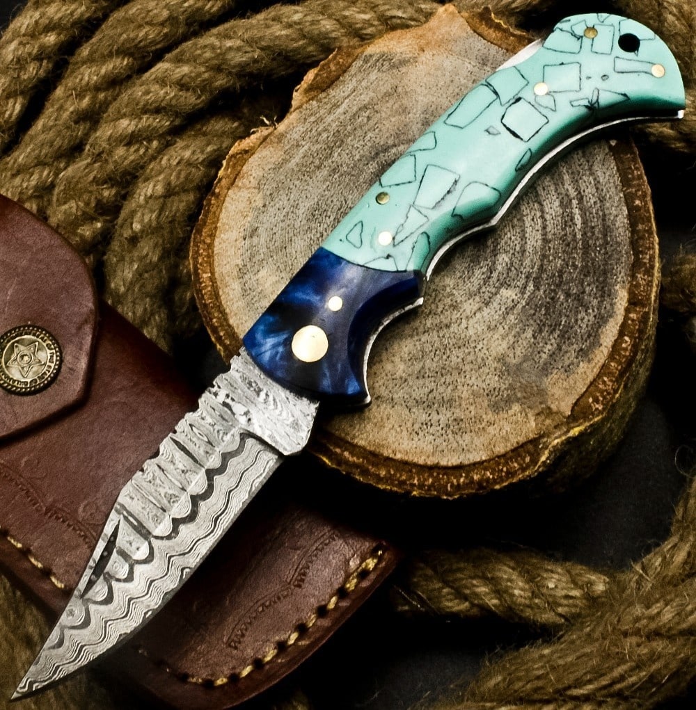 Teal Mosaic Corian Handle Damascus Knife Wavy: Size: Length 17.1 cm - Blade 7.6 cm. Materials: Damascus steel, corian, brass, leather. Condition: New. This folding pocket knife features a distinctive Damascus steel blade, characterized by its