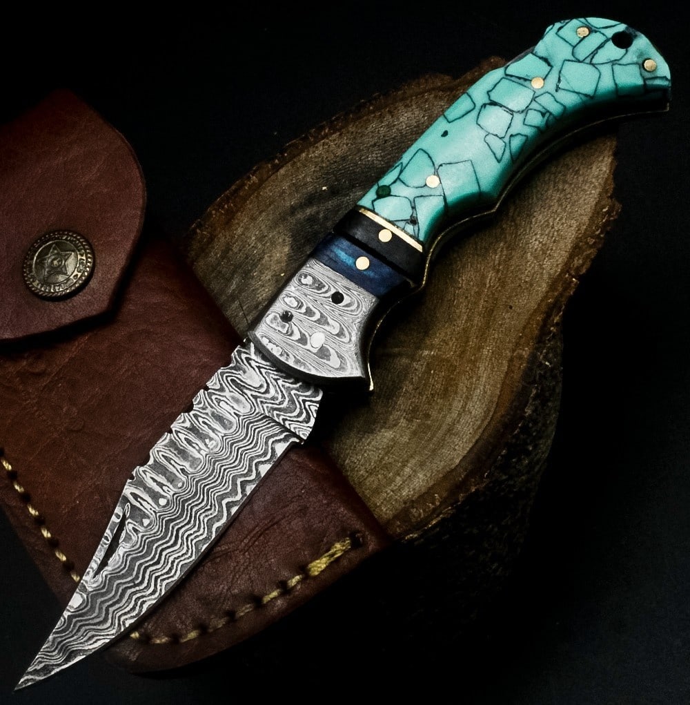 Twist Pattern Damascus Folding Knife Resin Custom: Size: Overall Length 17.8 cm - Blade Length 7.6 cm - Handle Length 10.2 cm. Materials: Damascus steel, resin, brass, leather. Condition: New. This custom handmade folding knife features a Damascus