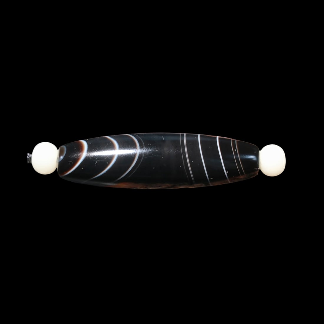 Tibet Agate Dzi Bead Amulet Line Silkworm Pattern: Size: Length 5.45 cm - Diameter 1.65 cm. Materials: Agate. Condition: Resembles a retro aesthetic. This Tibetan ji bead is an elongated cylindrical amulet, expertly crafted from agate, featuring the r