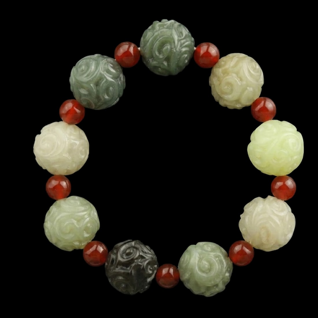 Vintage Jade Carved Drum Bead Scrolling Motif Bracelet: Size: Beads Width 1.7 cm. Weight 76 g. Materials: Jade Condition: Looks like vintage This ornate bracelet is composed of substantial drum-shaped beads, each meticulously engraved with rhythmic scrolli