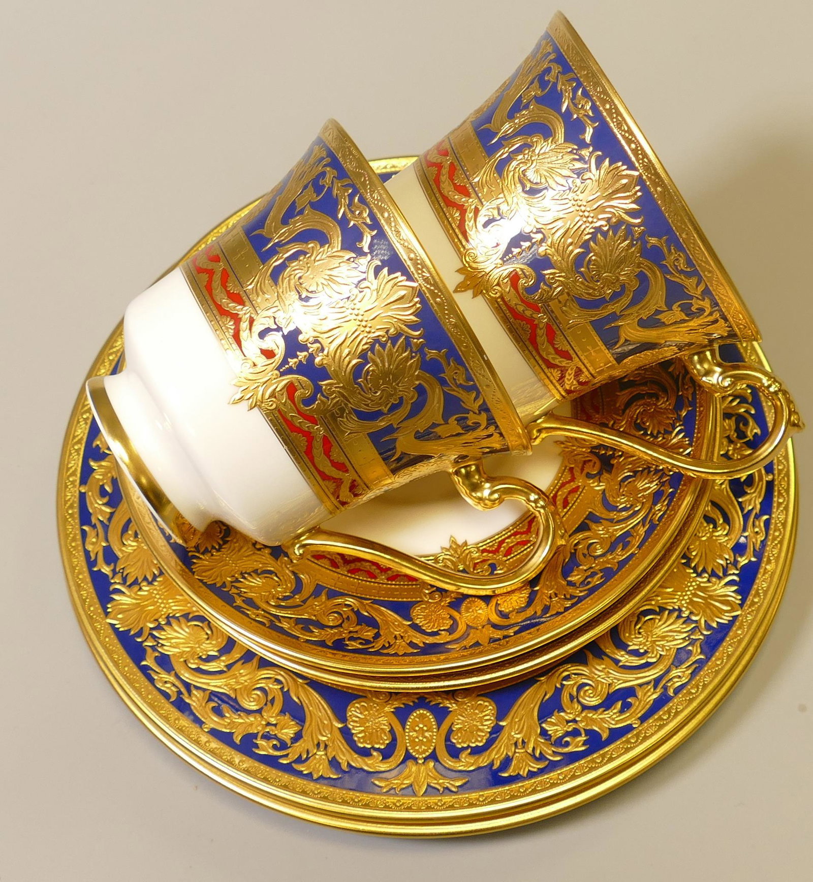 De Lamerie Fine Bone China heavily gilded Dark Blue Empress patterned trios, specially made high end: De Lamerie Fine Bone China heavily gilded Dark Blue Empress patterned trios, specially made high end quality items, made in England. (2)