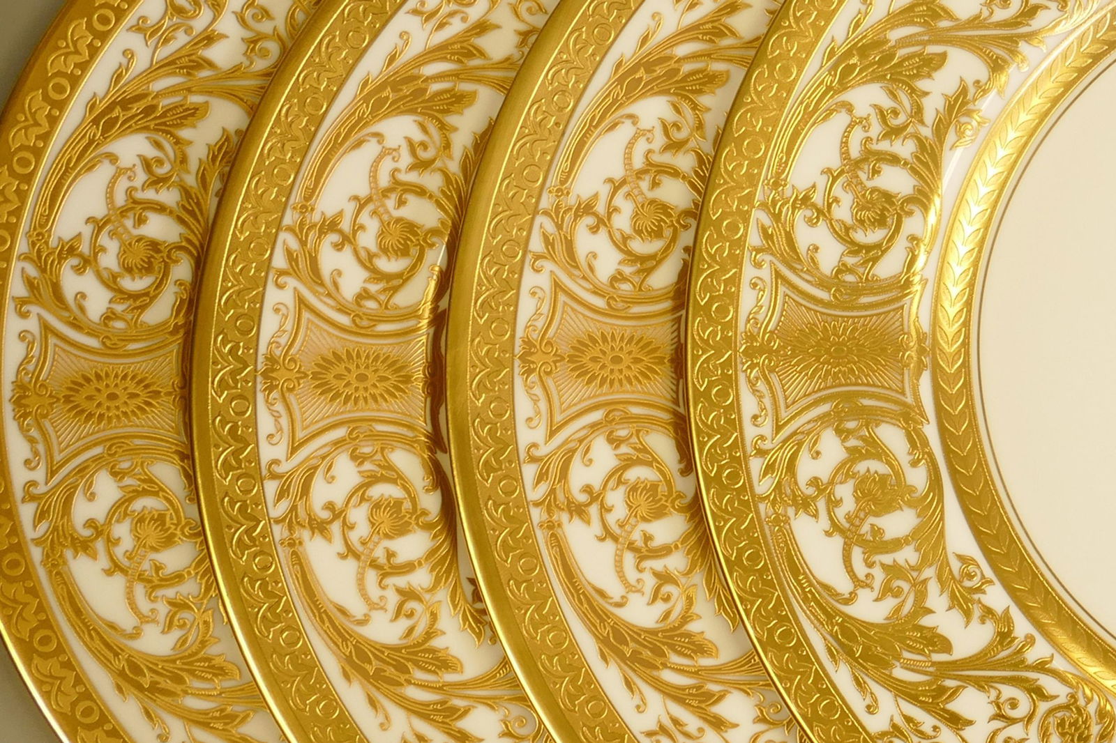 De Lamerie Fine Bone China heavily gilded Robert Adam patterned dinner plates, specially made high: De Lamerie Fine Bone China heavily gilded Robert Adam patterned dinner plates, specially made high end quality items, made in England, diameter 27cm. (4)