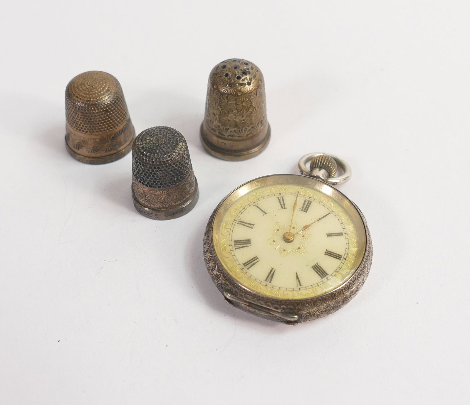 Ladies silver cased pocket watch, winds and ticks, together with 3 sterling silver thimbles.: Ladies silver cased pocket watch, winds and ticks, together with 3 sterling silver thimbles.