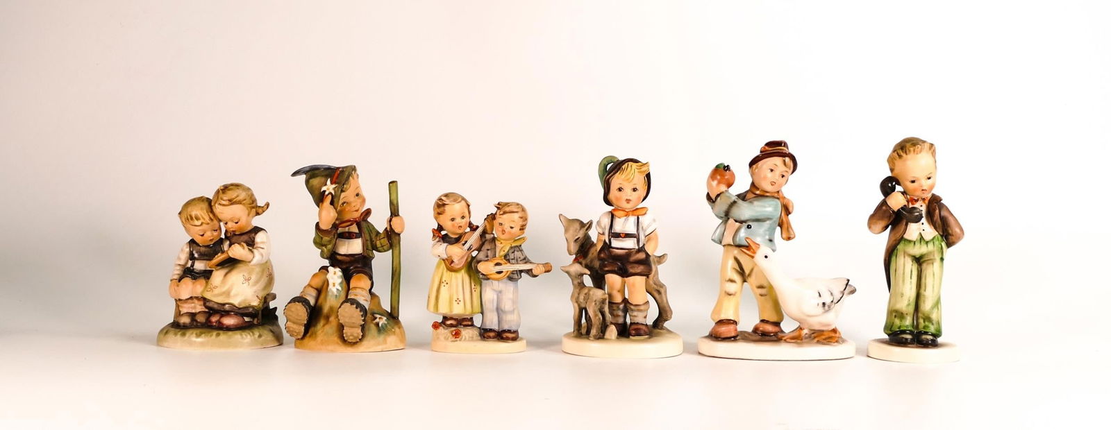 A collection of Goebel Hummel figures including Smart Little Sister, Mountaineer Hiking Boy, Goat (1 of 2)