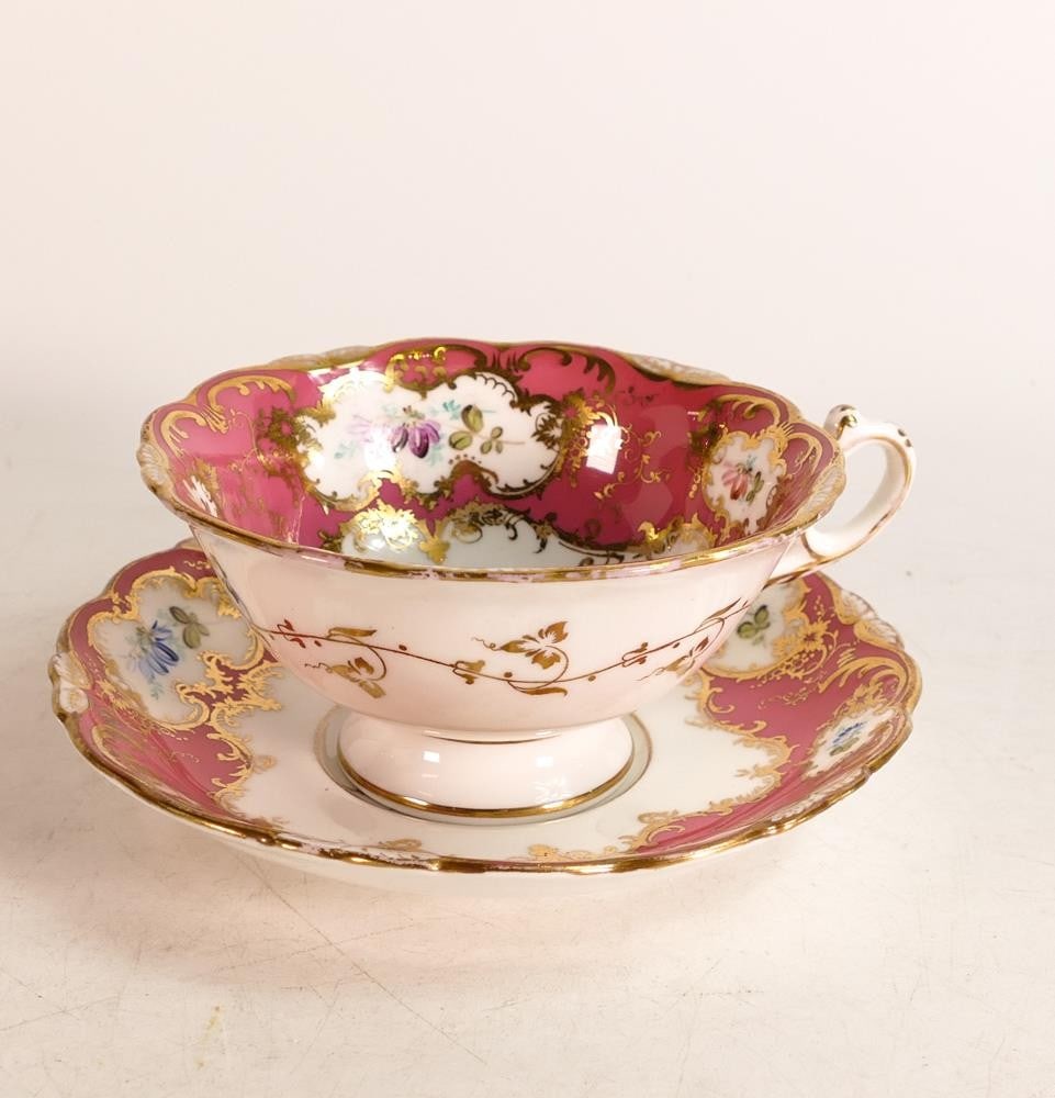 Coalport hand painted porcelain tea cup and saucer. Painted with floral spray reserves by F Howard.: Coalport hand painted porcelain tea cup and saucer. Painted with floral spray reserves by F Howard. Gilt Rococo borders on pink ground. Height of tea cup: 5.9cm diameter of saucer: 15cm