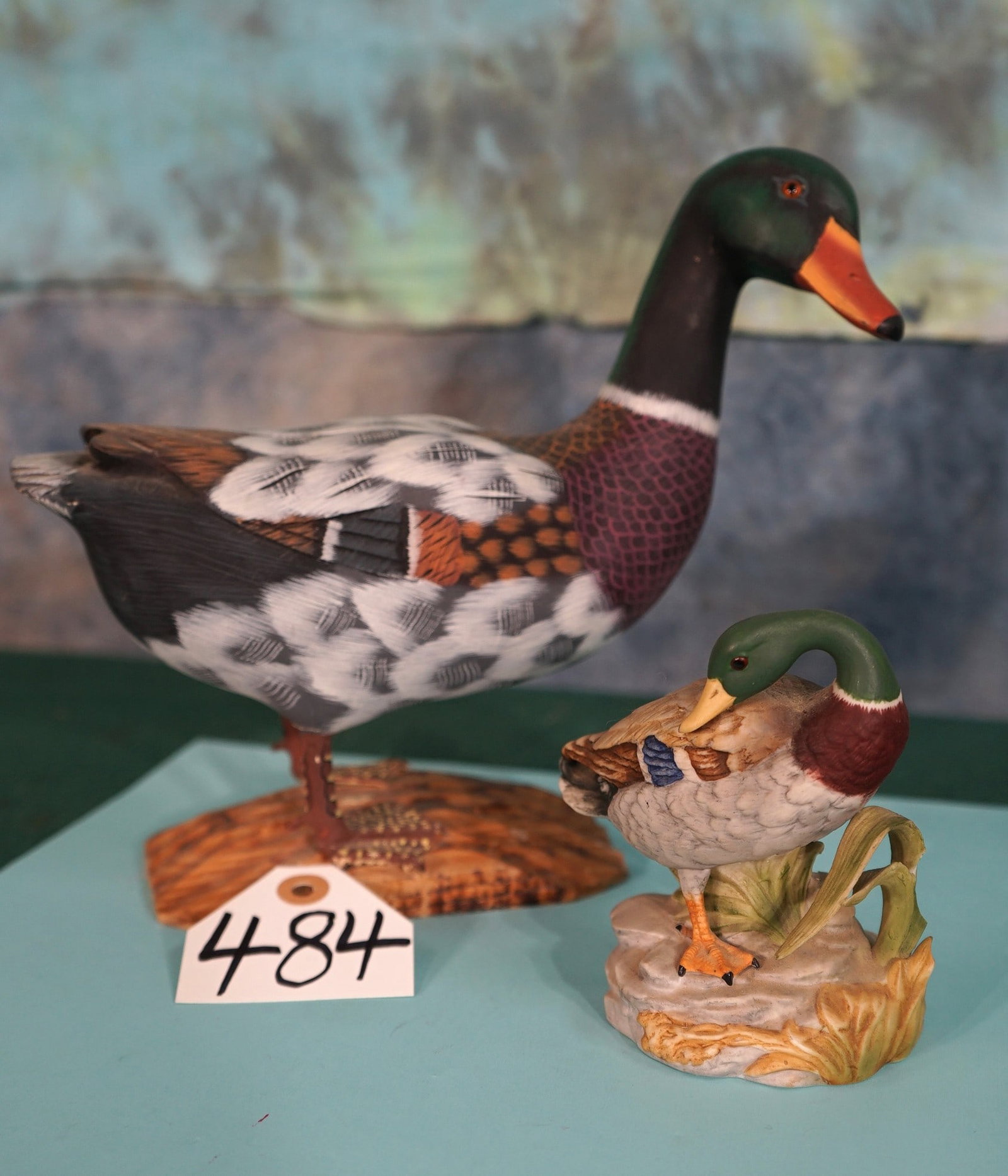 Two Mallard Duck Drakes: One Carved from Wood, and the other made from Ceramics. These Mallard Drake statues are quite unique in their own way. The larger one, made of wood has a beautiful paint job; and the smaller Ceramic o