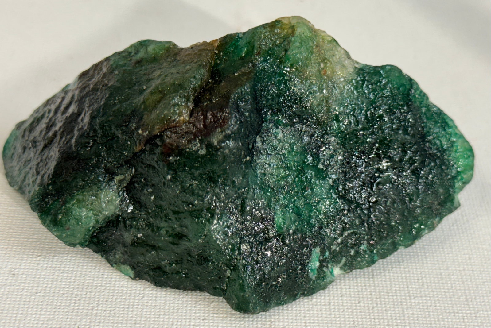 Rough Uncut 947.95Ct. Natural Emerald Gemstones: This is a very large rough, uncut, natural Emerald from Columbia mines. A lamp light will show edges of the Gemstone that are partially translucent.