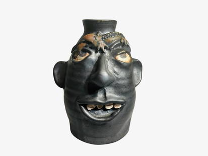 Kim Black Lizard Face Jug: Mint condition. Metallic black glazed face jug with applied lizard. Signed and dated 1999 on bottom. Stands 7.5 inches tall.
